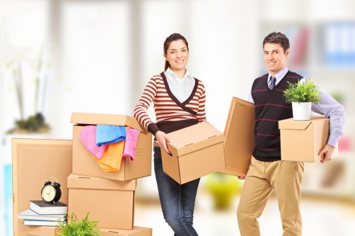 Professional movers carrying boxes inside a Finchley property